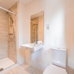 En suite shower room with modern tiling and glass enclosure