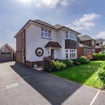 Front exterior of detached home with driveway and separate garage at Hartford property