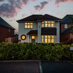 Front exterior of detached home with driveway, garage and twilight lighting at Hartford property