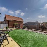 Garden with artificial lawn, patio seating and raised levels