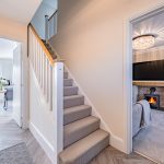 Hallway with staircase and view into living room with log burner