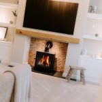 Living room with log burner fireplace, brick surround and built-in shelving