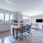 Open plan kitchen dining and living area with herringbone flooring