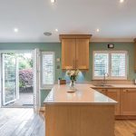 Kitchen with central island, shaker cabinetry and patio doors opening to the garden
