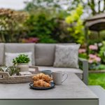 Outdoor seating detail at 11 Sandington Drive, Cuddington, with patio furniture, breakfast setting and established garden beyond.