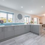 Open plan kitchen and dining area at 11 Sandington Drive, Cuddington, with bright neutral décor and connection to the garden room.