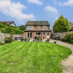 Rear patio and garden at 211 Hartford Road, Davenham, with paved seating areas, lawn and established boundary planting.