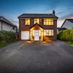 Twilight front exterior of 211 Hartford Road, Davenham, with illuminated windows, driveway and garage.