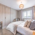 Double bedroom at 39 Albemarle Avenue, Hartford, with fitted wardrobes, neutral décor, window blinds and layered soft furnishings.