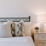 Bedroom styling detail featuring layered cushions, bedside furniture and soft neutral décor within a detached family home in Kingsmead