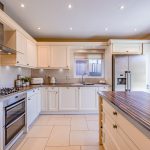 Shaker-style family kitchen with central island, integrated appliances and garden access in a detached Kingsmead home