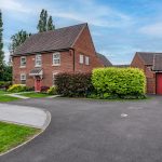 Front exterior of 18 Brooke Avenue, Winnington, showing the detached home, landscaped approach, driveway and separate garage.