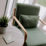 Garden room detail at 18 Brooke Avenue, Winnington, with green armchair, side table, potted plant and natural light from the glazed doors.