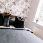 Contemporary double bedroom with vaulted ceiling, feature wall and roof window creating a bright, relaxing space.