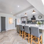 Spacious open-plan kitchen and dining area with central island, breakfast bar and contemporary finishes at 5 Woburn Close, Kingsmead.