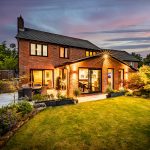 Twilight rear elevation showcasing the contemporary extension, landscaped garden and outdoor entertaining space.