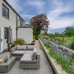 Outdoor terrace and seating area at Brooklyn Cottage in Lostock Green with views across surrounding countryside.