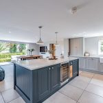 Kitchen island and family room at Brooklyn Cottage in Lostock Green, creating a relaxed and sociable layout for modern living