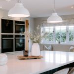 Kitchen island detail at Brooklyn Cottage featuring quartz worktops, pendant lighting and bespoke cabinetry