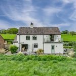 Rear elevation of Brooklyn Cottage captured from above showing landscaped gardens, entertaining areas and countryside views.