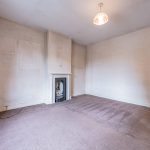 Bedroom with retained period fireplace at The Hollies, a character home in Moulton, Cheshire.
