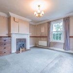 Character reception room with traditional fireplace and period detailing at The Hollies in Moulton, Cheshire.