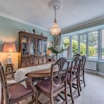 Separate dining room at The Poplars with a broad window overlooking the established rear garden.