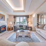 Generous family room at The Poplars with feature fireplace, soft lighting and views towards the front of the property.