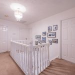 Spacious first floor landing with white balustrade, carpeted flooring and doors to the bedrooms at 3 Monarch Drive