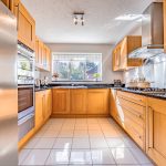 Fitted kitchen with oak cabinets, integrated oven, gas hob and stainless steel fridge freezer at 3 Monarch Drive