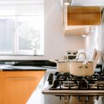 Kitchen lifestyle detail featuring a gas hob, cooking pans and dark worktops at 3 Monarch Drive